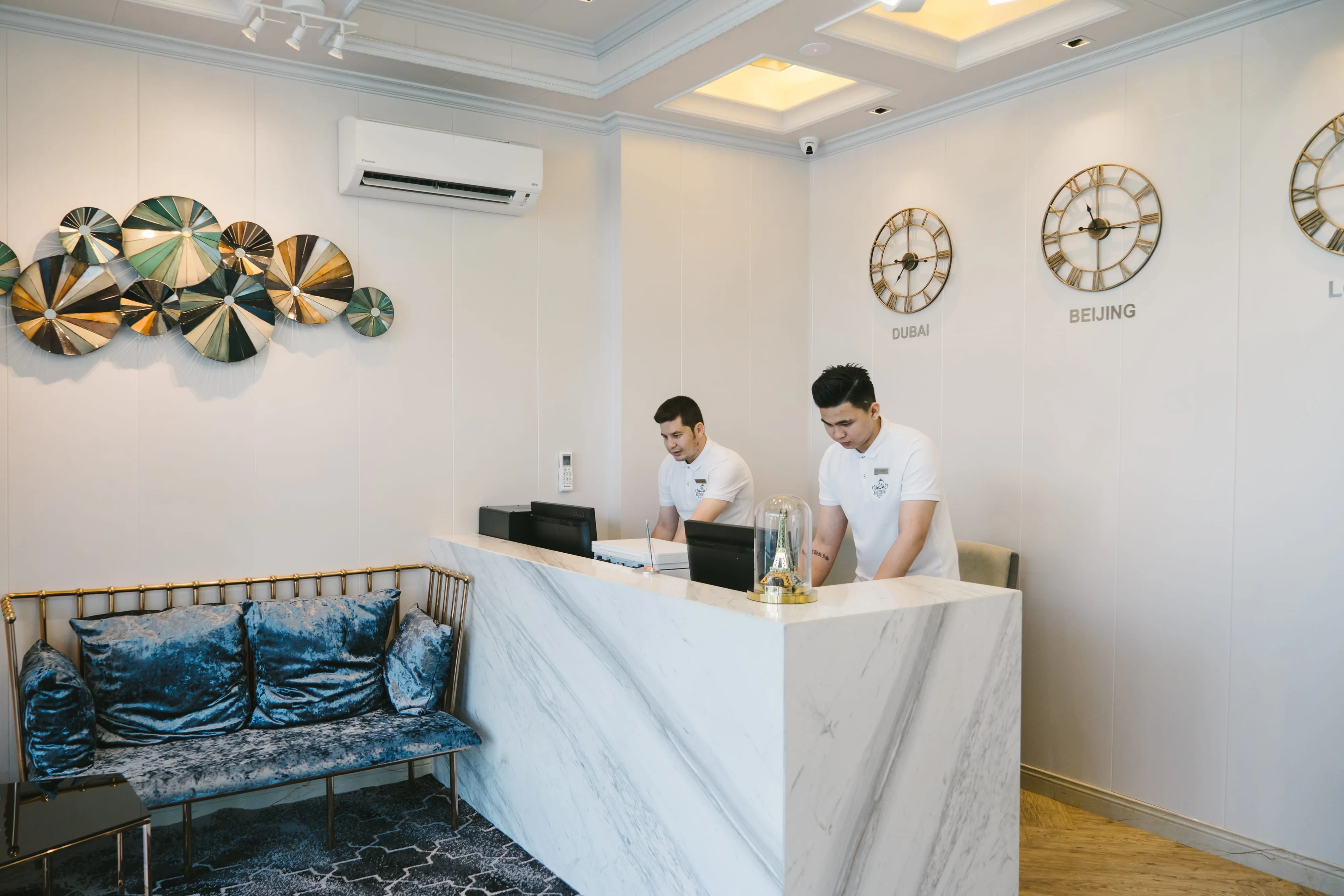Reception desk with staff and world clocks, A&R Boutique Hotel